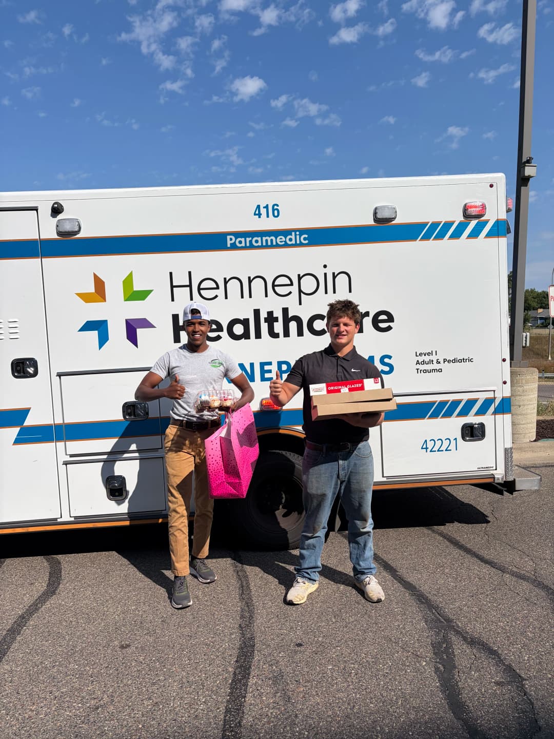 Hennepin Healthcare paramedics delivering food donations outside an ambulance.