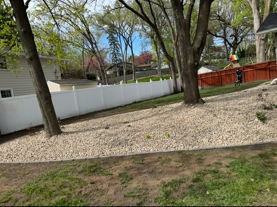River Rock and Paver Edging Around a Backyard Tree Line image